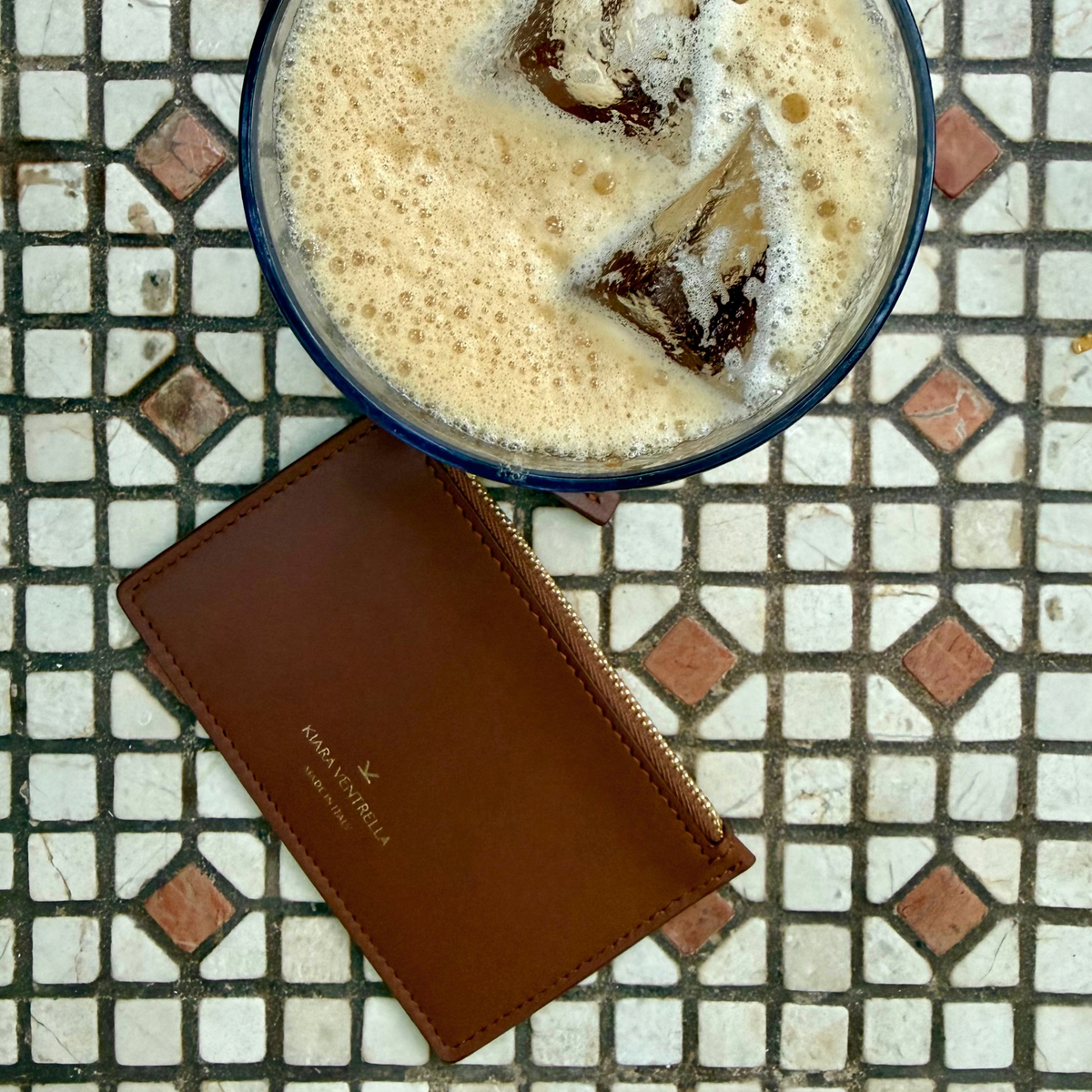Lifestyle: Card Case Slim Smooth Brown leather (Chestnut), zip closure, iced coffee, carajillo, K Kiara Ventrella Gold Foil Logo.