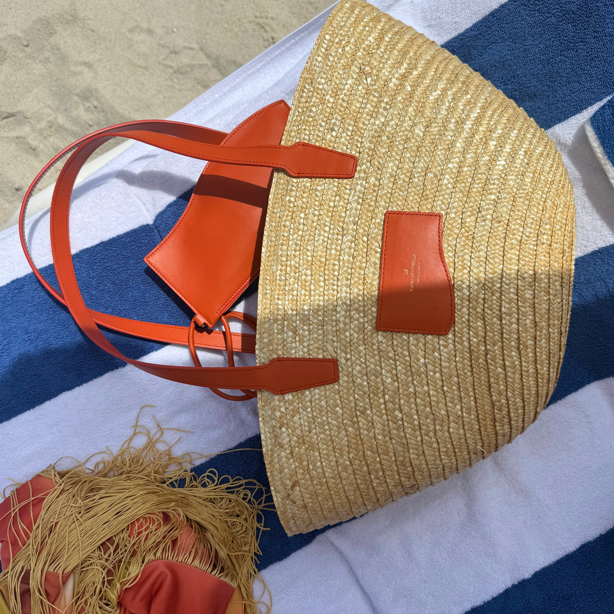 Large Marea Straw Tote Bag with Marea Wave Pouch fastened to shoulder strap. Both shown in Toasted Orange Smooth Leather.